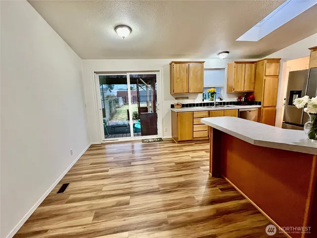 a large kitchen with granite countertop a large counter top stainless steel appliances and cabinets