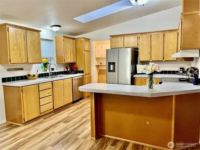 a kitchen with stainless steel appliances granite countertop a sink stove and refrigerator