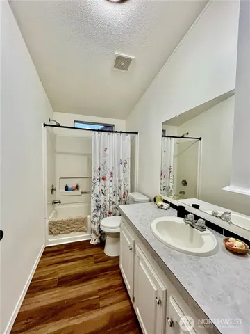 a bathroom with double vanity sinks a mirror and a shower