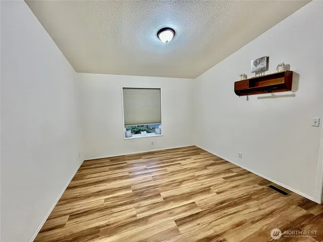 a bedroom with a bed and a painting on the wall