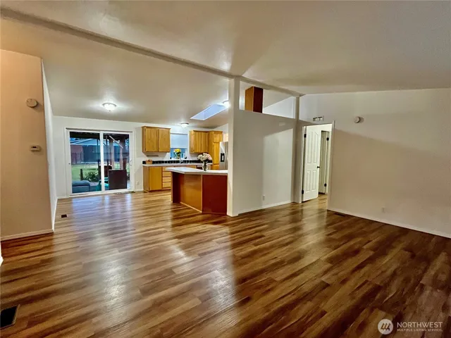a view of a kitchen with wooden floor and a refrigerator