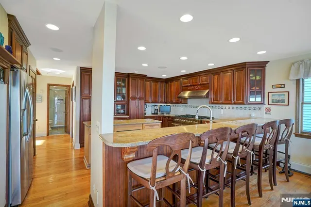 a kitchen with stainless steel appliances granite countertop wooden cabinets a stove top oven a sink and dishwasher