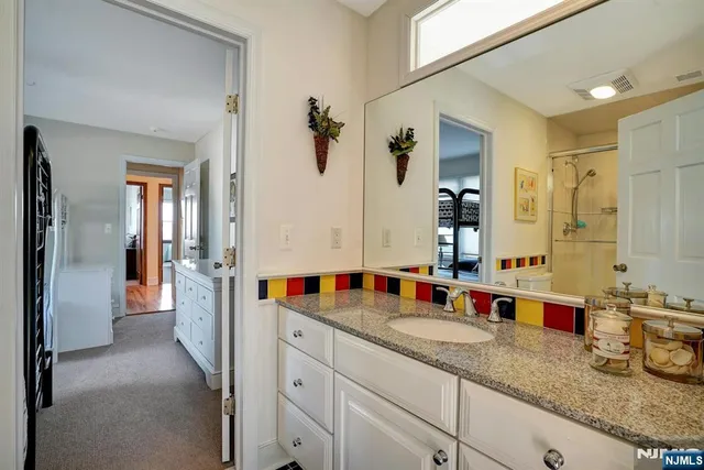 a bathroom with double vanity and a mirror