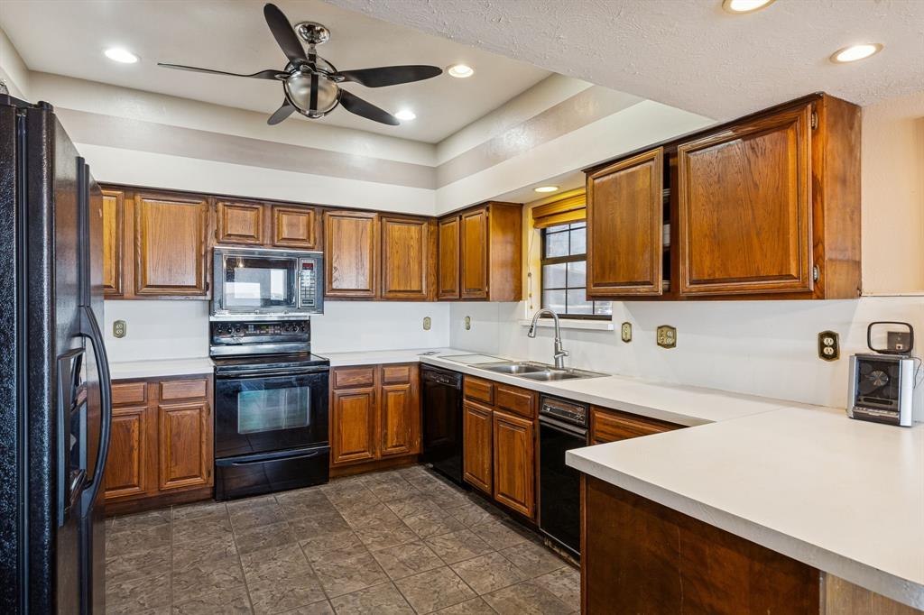 4548 Chaha Road, Unit 203 Garland, TX 75043 - Photo 12 of 18 a kitchen with stainless steel appliances granite countertop a sink stove and refrigerator