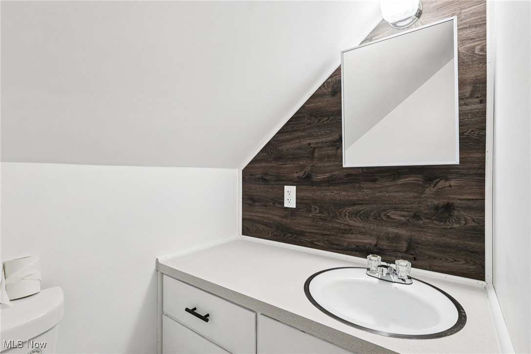 5898 Keller Road Akron, OH 44319 - Photo 22 of 32 Half bath featuring vanity and lofted ceiling