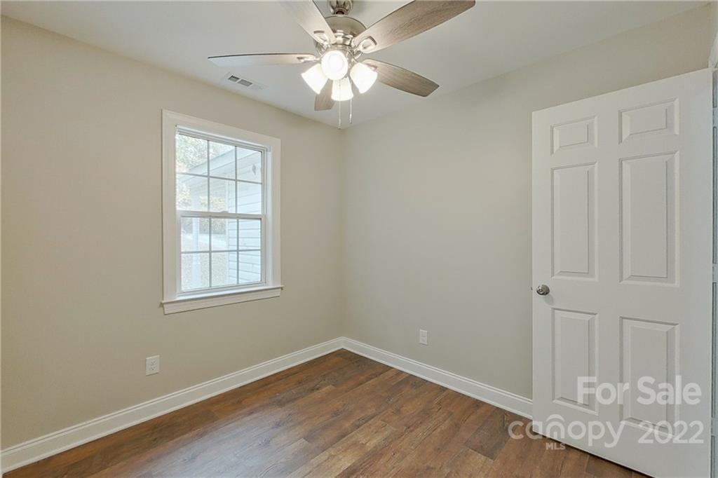 3804 Dusty Hollow Road Monroe, NC 28110 - Photo 11 of 42 an empty room with wooden floor fan and windows