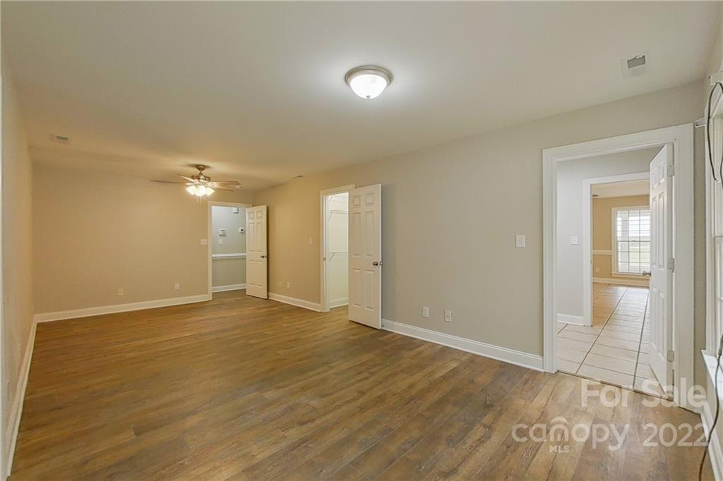 3804 Dusty Hollow Road Monroe, NC 28110 - Photo 6 of 42 a view of an empty room with wooden floor and a mirror