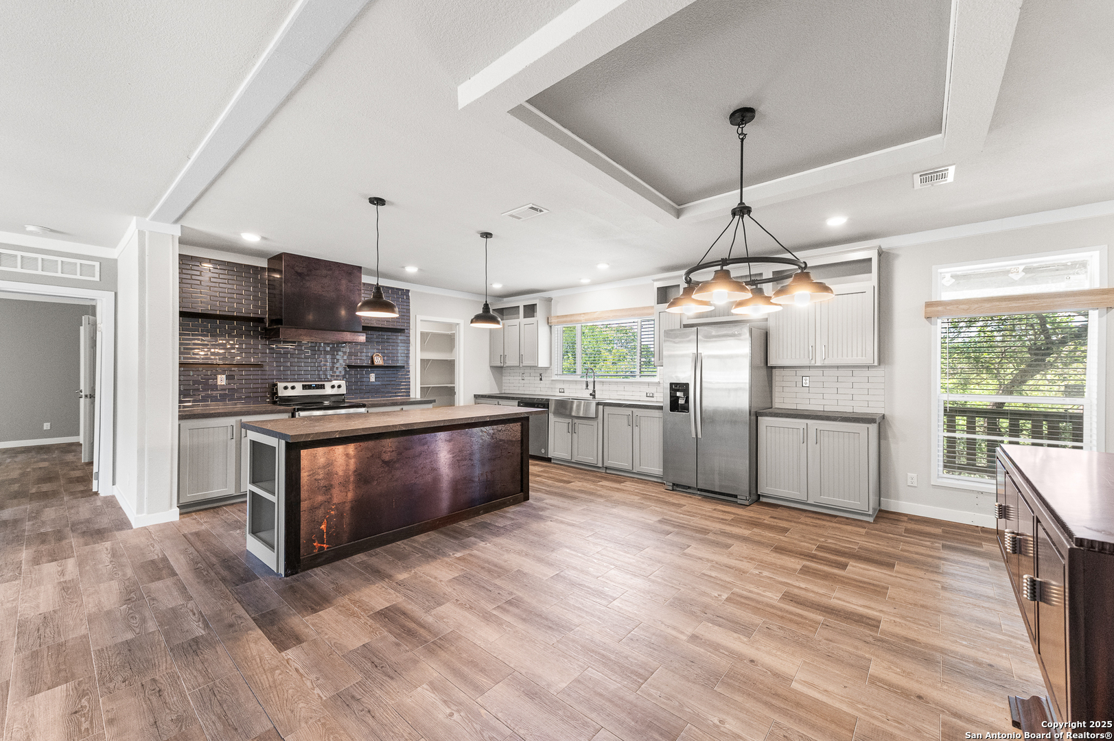 9130 Rebecca Creek Road Spring Branch, TX 78070 - Photo 12 of 77 a large kitchen with stainless steel appliances kitchen island granite countertop a large counter top and wooden floors