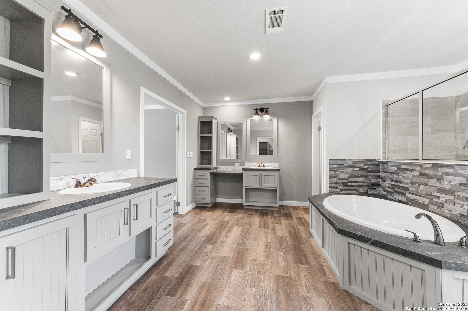 9130 Rebecca Creek Road Spring Branch, TX 78070 - Photo 22 of 77 a bathroom with a granite countertop double vanity sink a mirror and a bathtub
