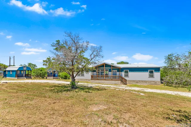 a view of a house with a yard and sitting area