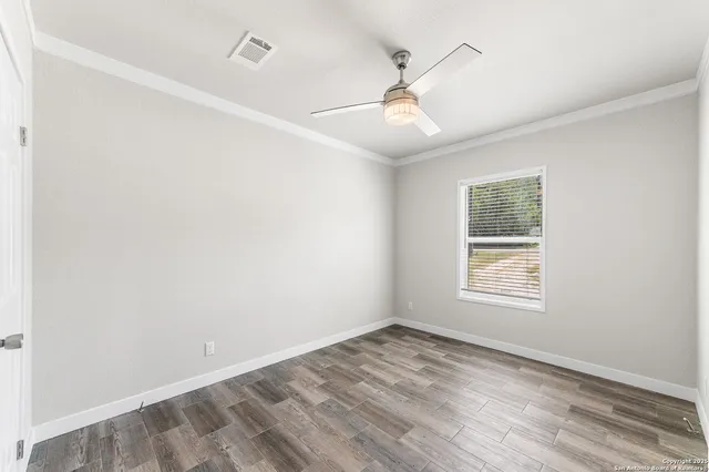 a view of an empty room with closet and wooden floor