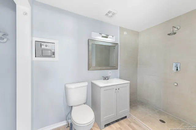 an aerial view of residential houses with outdoor space and trees