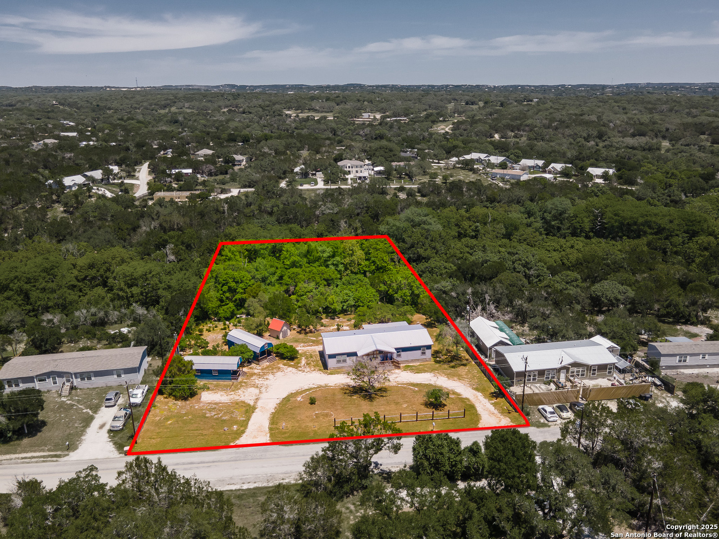 9130 Rebecca Creek Road Spring Branch, TX 78070 - Photo 75 of 77 an aerial view of residential houses with outdoor space and trees
