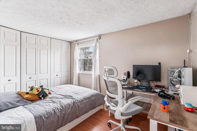 a bedroom with a bed and a computer on the desk
