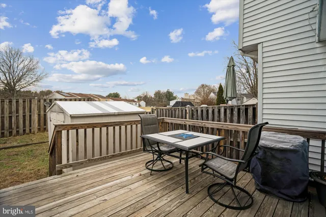 a view of a roof deck with table and chairs with wooden floor and fence