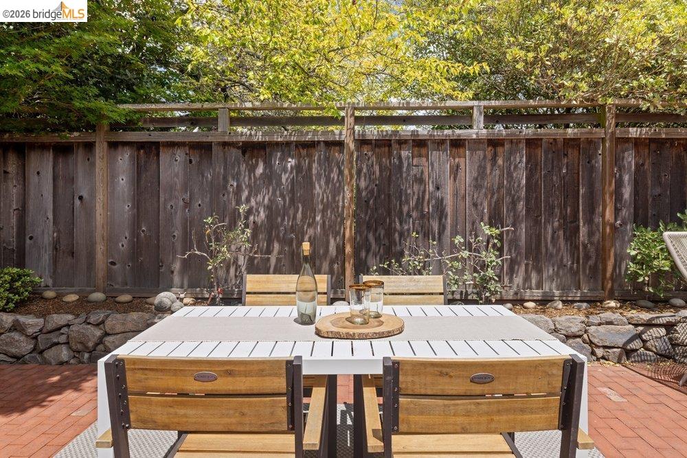 287 Purdue Avenue Kensington, CA 94708 - Photo 37 of 60 Brick patio featuring a wooden privacy fence, stone retaining wall, and mature landscaping