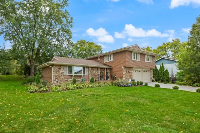 a view of a house with a big yard and large trees