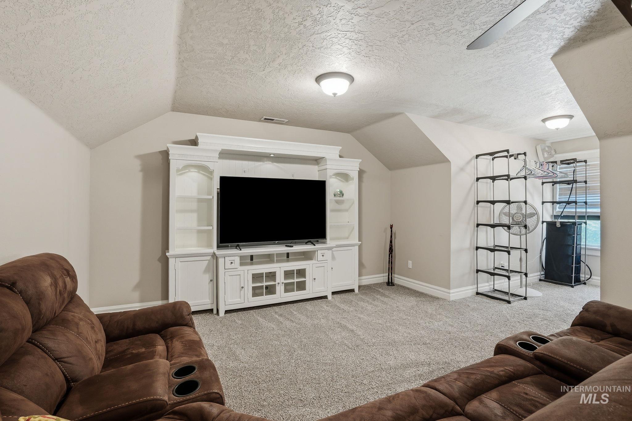 3969 North Hollymount Way Meridian, ID 83646 - Photo 34 of 47 Carpeted entertainment space featuring a built-in white media console with shelving and base cabinets