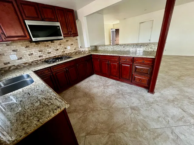 a kitchen with stainless steel appliances granite countertop a stove microwave and sink