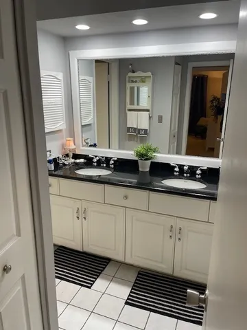 a bathroom with a sink a mirror and a window