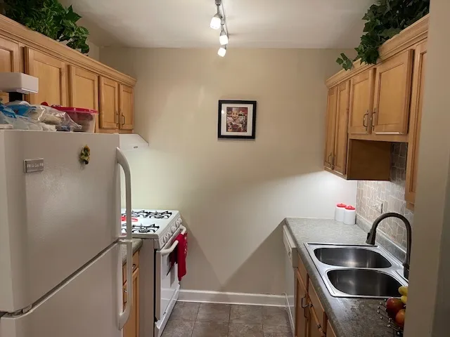 a kitchen with stainless steel appliances granite countertop a sink refrigerator and cabinets