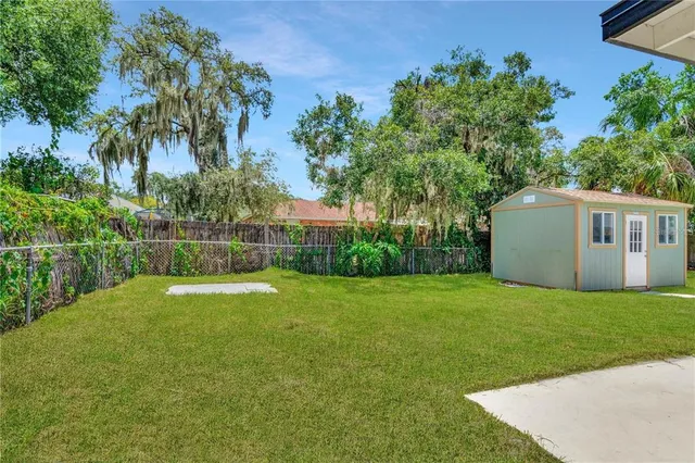 a view of a house with backyard and a tree