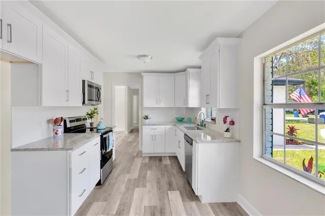 a kitchen with a sink wooden floor and window