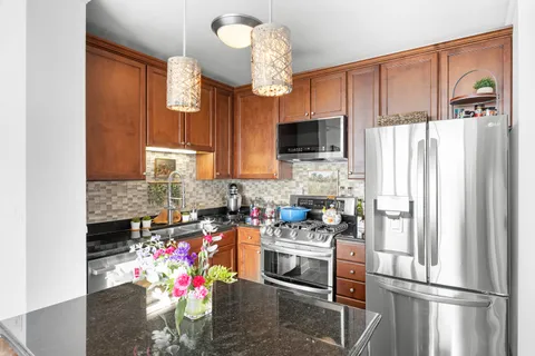 a kitchen with sink refrigerator dining table and chairs