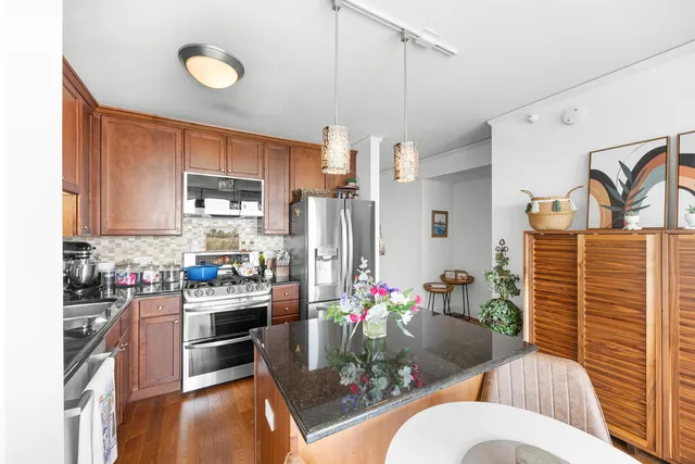 a kitchen with stainless steel appliances granite countertop a stove a sink and a refrigerator