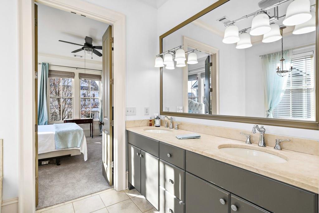 402 Prosper Circle, Unit 102 Marietta, GA 30060 - Photo 23 of 72 a en suite bathroom with a double vanity sink a mirror and a bathtub