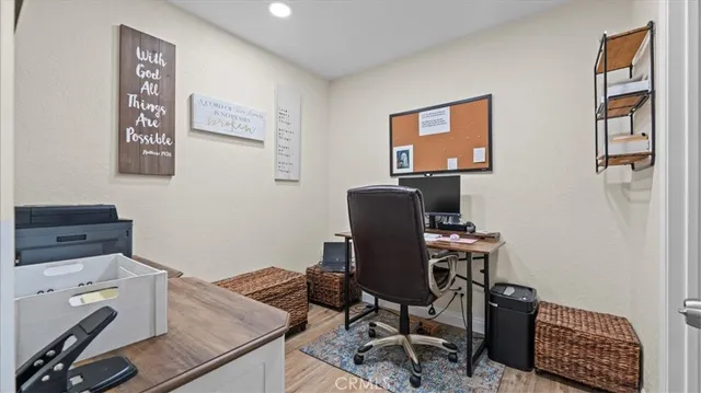 a view of a workspace with furniture and wooden floor