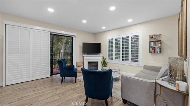a living room with furniture a flat screen tv and a floor to ceiling window