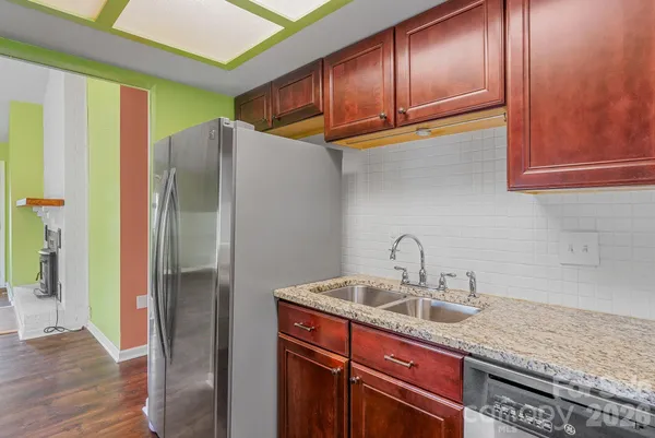 a kitchen with stainless steel appliances granite countertop a refrigerator and a sink