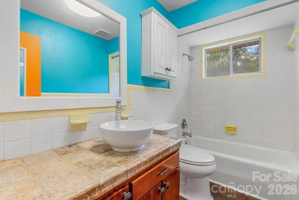 a bathroom with a granite countertop toilet sink and mirror