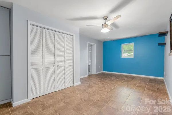 a view of a livingroom with a ceiling fan and window