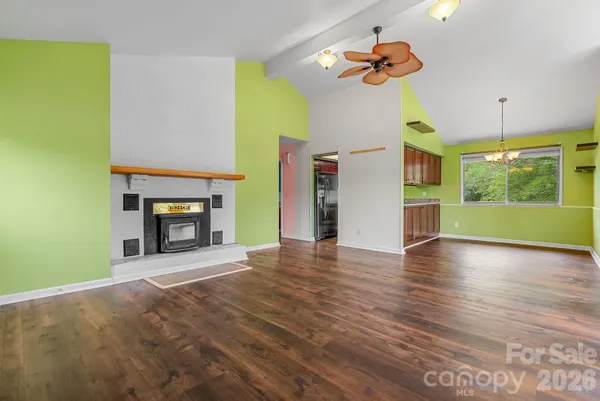 a view of an empty room with a fireplace and a window