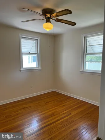 a view of empty room with wooden floor and window