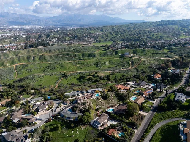 an aerial view of residential houses with outdoor space and trees