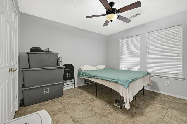 a bedroom with a bed and a ceiling fan