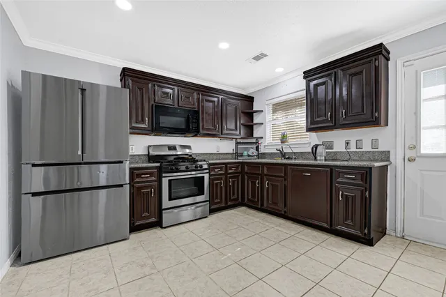 a kitchen with stainless steel appliances granite countertop a refrigerator stove top oven and sink