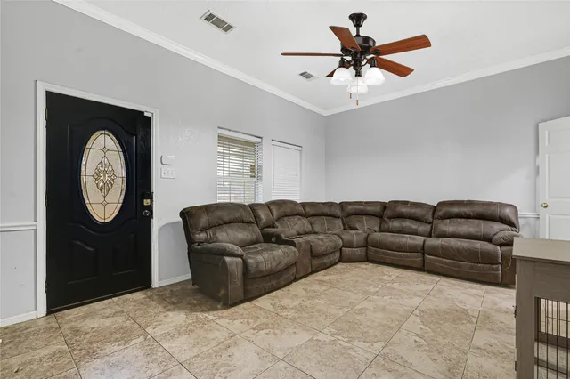 a living room with furniture a clock and a ceiling fan