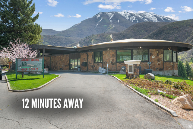 2042 Valley Drive, Unit 57 Mapleton, UT 84664 - Photo 12 of 18 Circular architectural design featuring stone facade, extensive windows, and a paved driveway