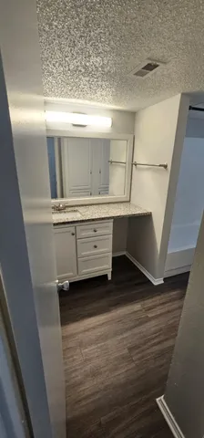 a kitchen with granite countertop a refrigerator a sink and wooden cabinets
