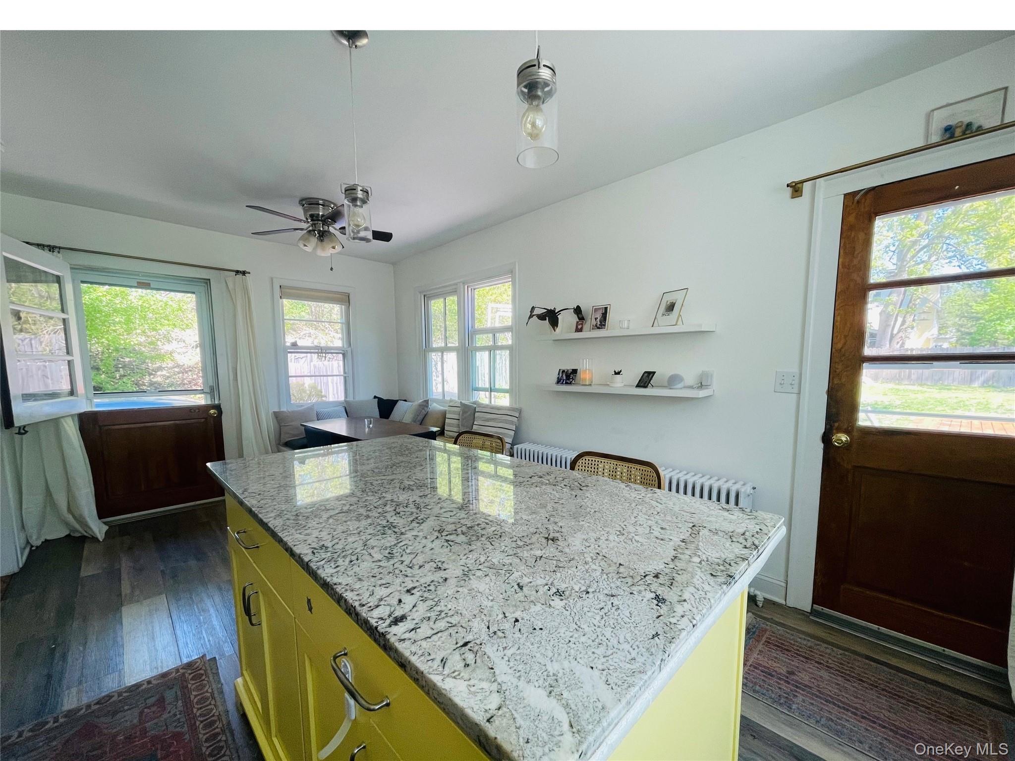 12 Parrott Street Cold Spring, NY 10516 - Photo 3 of 18 Kitchen featuring ceiling fan, light stone countertops, a kitchen island, and wood floors