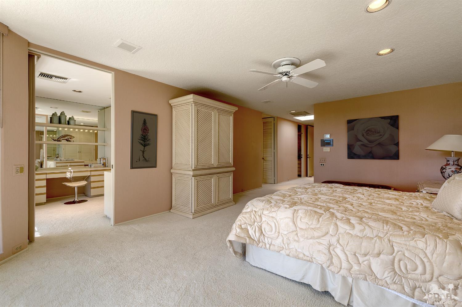 24 Johnar Boulevard Rancho Mirage, CA 92270 - Photo 14 of 26 a spacious bedroom with a bed and a large mirror