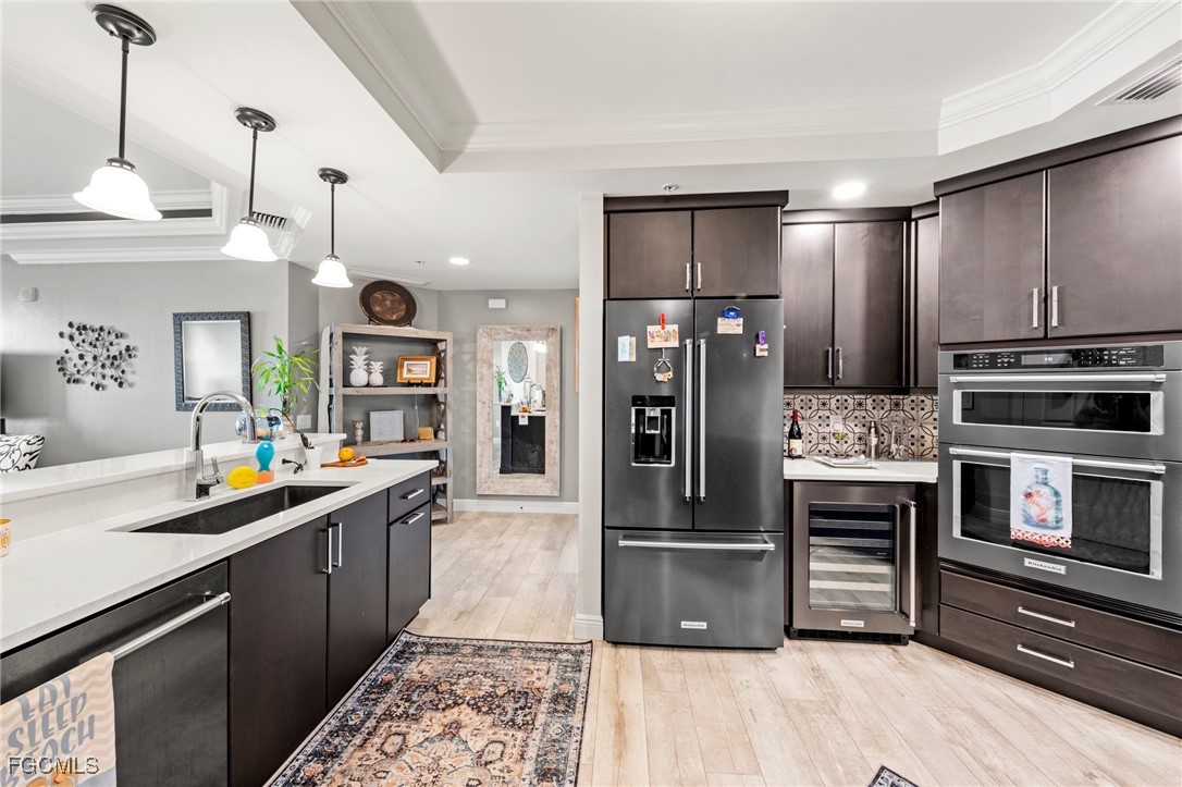 2745 First Street, Unit 1602 Fort Myers, FL 33916 - Photo 10 of 49 a kitchen with stainless steel appliances kitchen island granite countertop a refrigerator a stove and a sink with wooden floor