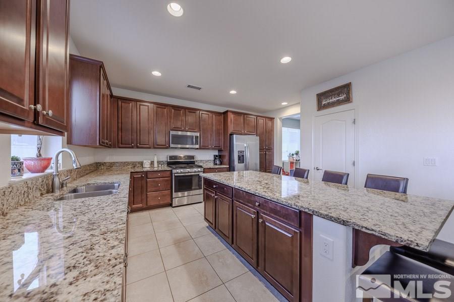 10062 Ignacio Circle Reno, NV 89521 - Photo 5 of 18 a large kitchen with granite countertop a large counter top stainless steel appliances and cabinets