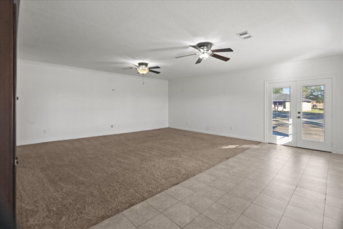 105 Alice Street Anahuac, TX 77514 - Photo 27 of 39 an empty room with windows and fan