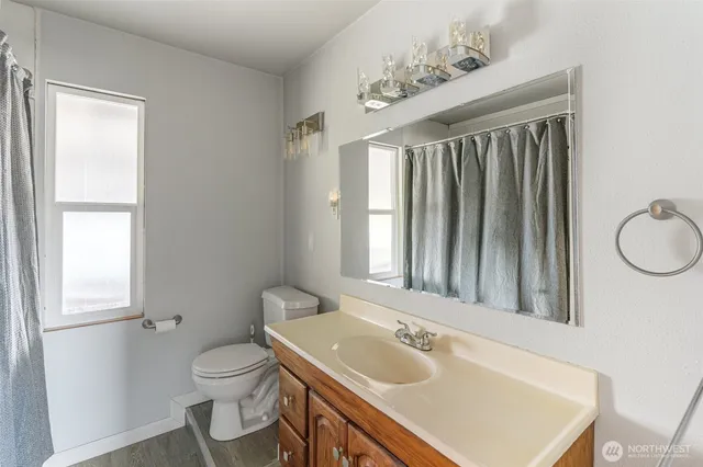 a bathroom with a sink toilet and mirror