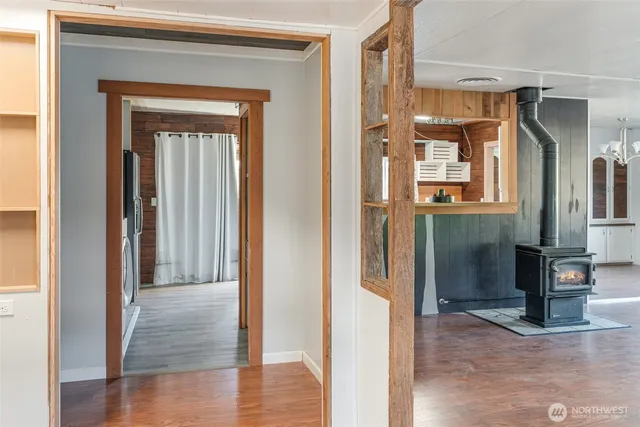 a view of a hallway with wooden floor and a cabinet